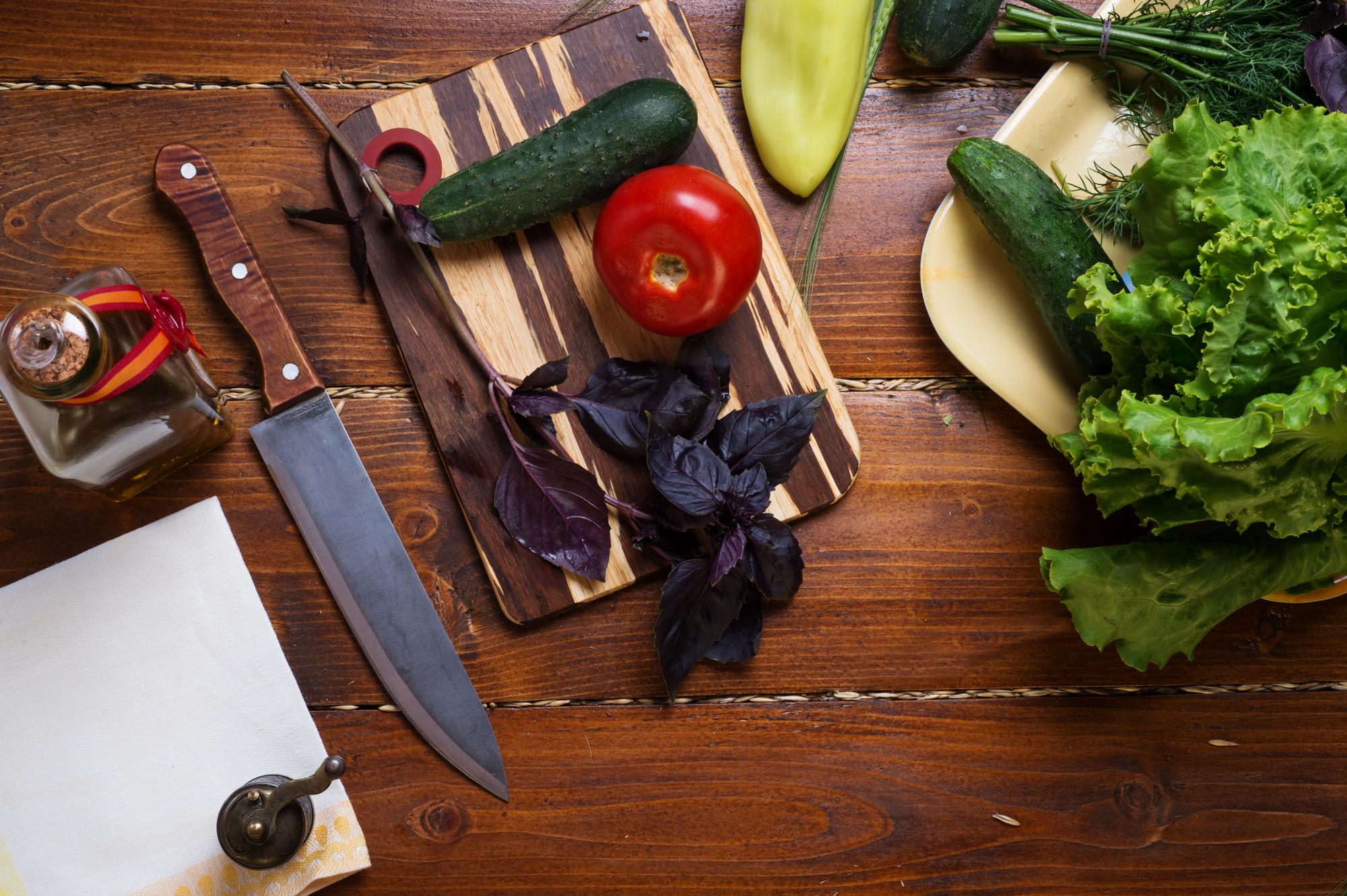 Studio table with knives, herbs and recipe notes
