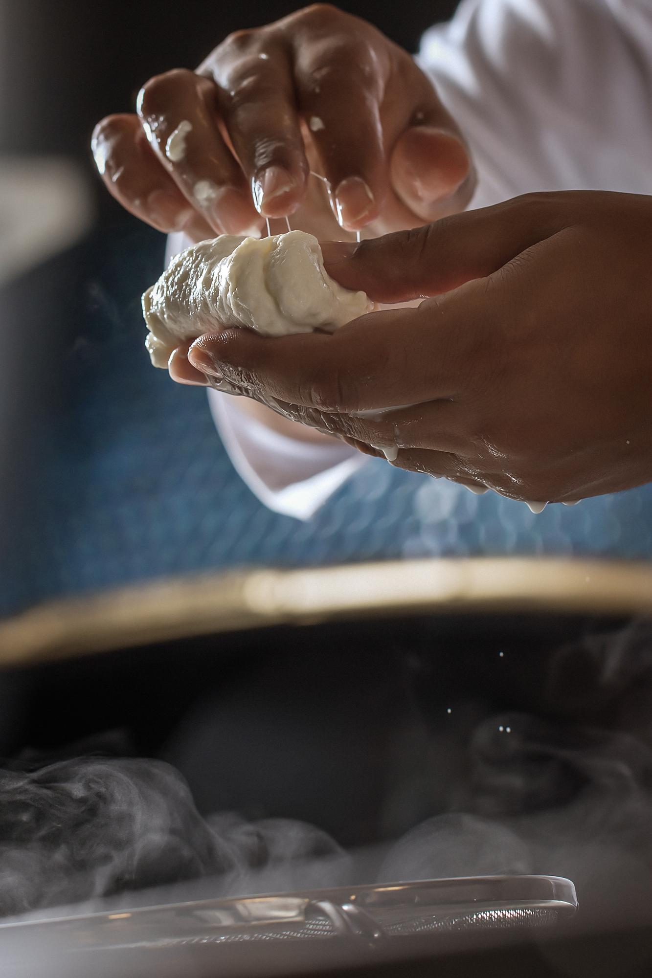 Hands kneading dough in workshop